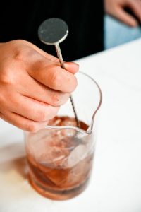 A negroni being stirred in a mixing glass 