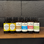 A display of Durham Distillery’s artisanal bitters for sale, including ginger, orange, chocolate, aromatic, rhubarb, and cardamom blends